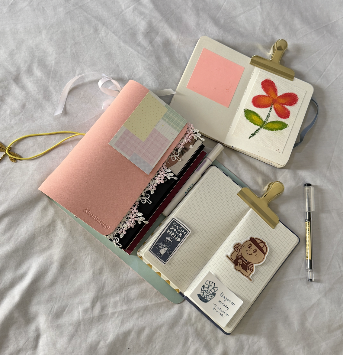 Little Scribbs journals and stationery arranged on a soft fabric backdrop